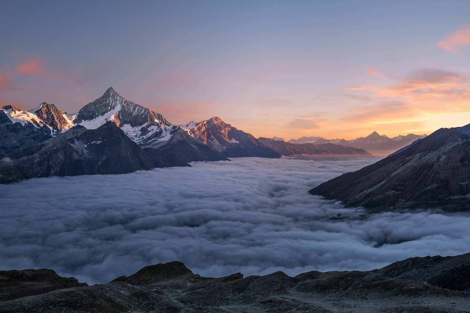 A mountain range above the clouds at first light